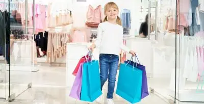 کودک در حال خرید لباس در فروشگاه